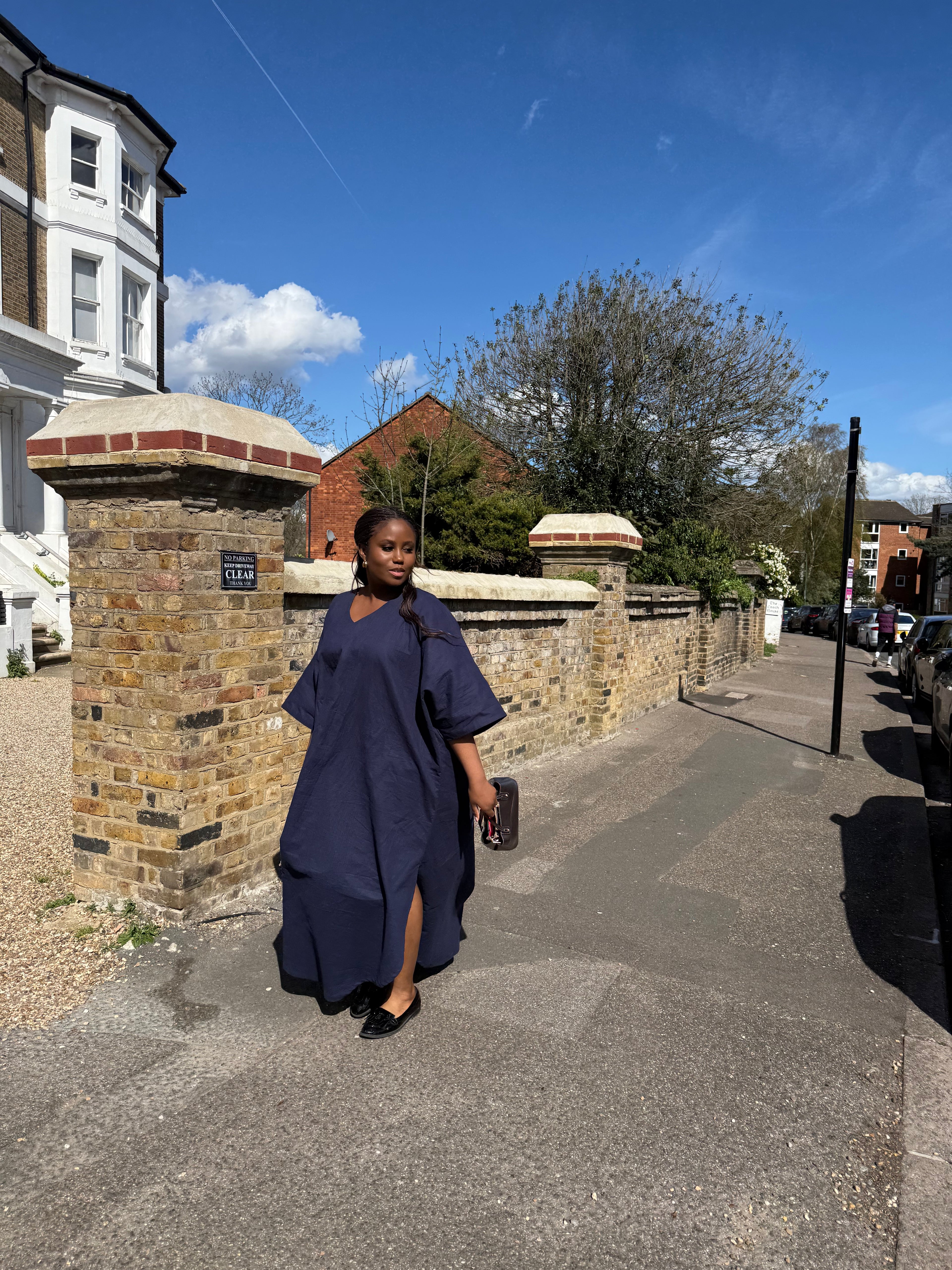 Person standing on a street with houses and trees in the background